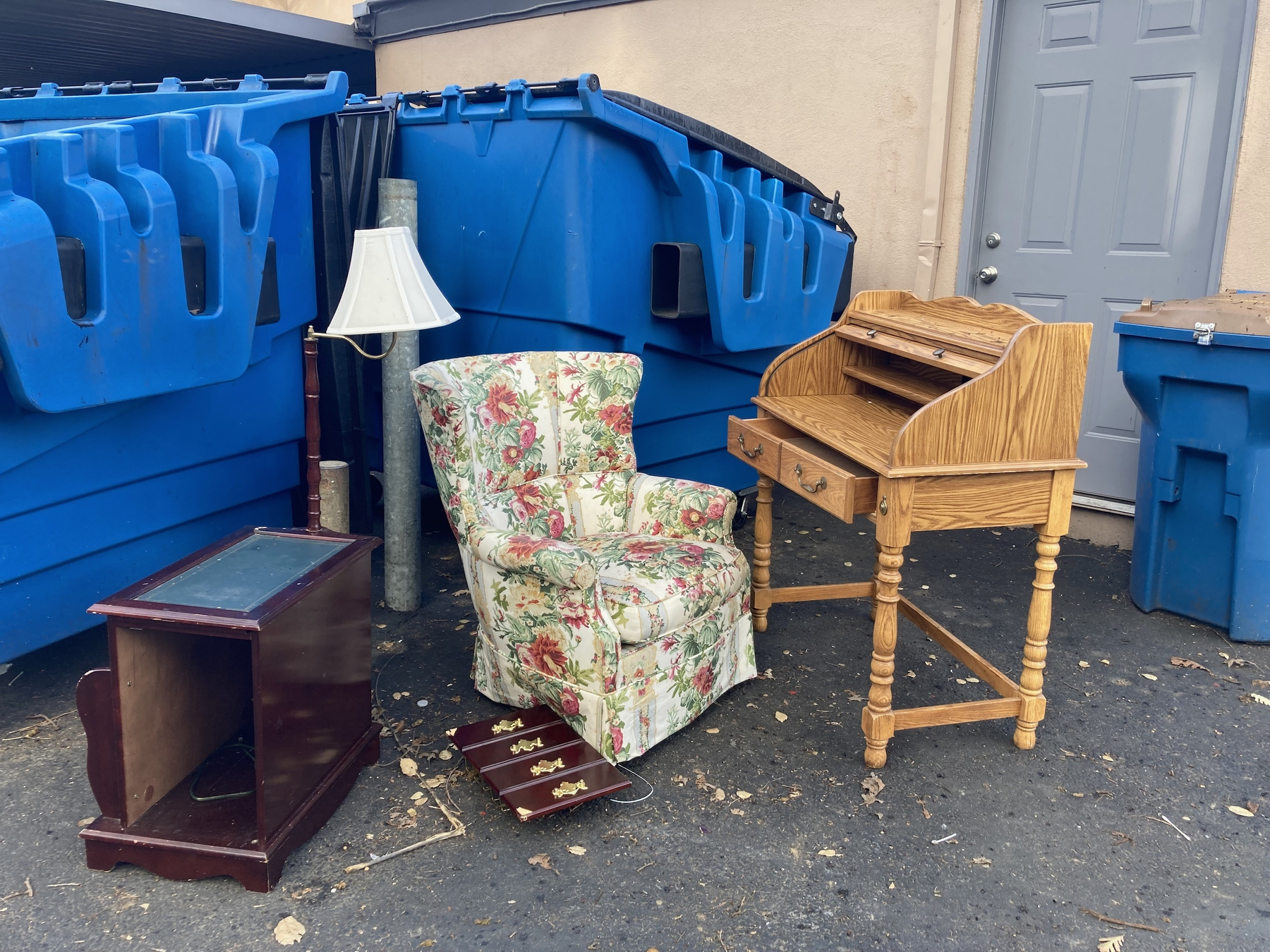 Loved but not wanted Furniture sitting next to a large garbage bin